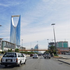 فعاليات الرياض في أكتوبر: شارع عام في مدينة الرياض يعج بالسيارات أمام برج المملكة الشاهق ذي العمارة الحديثة.
